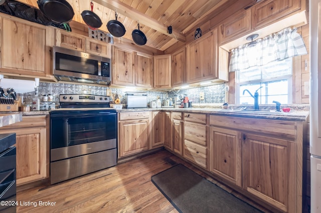 kitchen with tasteful backsplash, stainless steel appliances, dark wood-style floors, and beam ceiling