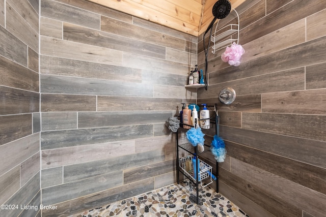 bathroom with wooden walls and tiled shower
