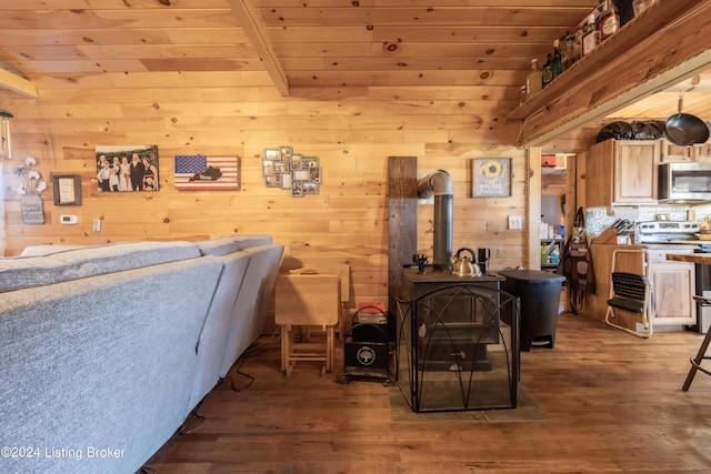interior space featuring wooden walls, wooden ceiling, a wood stove, and hardwood / wood-style flooring