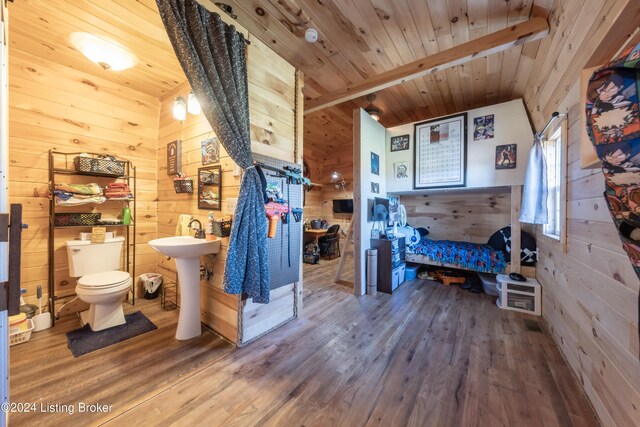 bathroom with wood finished floors, wooden walls, toilet, and wooden ceiling