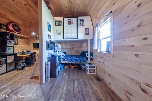 bedroom with wooden walls, visible vents, wooden ceiling, and wood finished floors