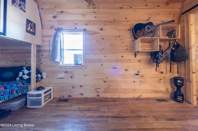 unfurnished bedroom featuring wood finished floors and wooden walls