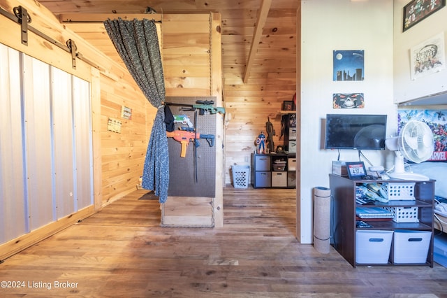 interior space featuring wood walls, a barn door, and wood finished floors