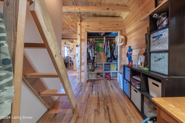 interior space featuring beamed ceiling, wood walls, wood ceiling, and hardwood / wood-style floors