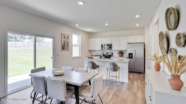 dining area featuring light wood-type flooring and a wealth of natural light