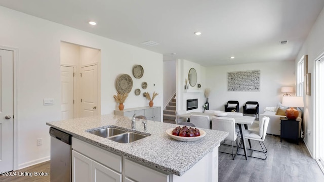 kitchen featuring white cabinetry, a kitchen island with sink, dishwasher, dark hardwood / wood-style floors, and sink