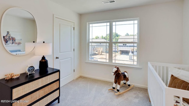 bedroom with light colored carpet and a crib