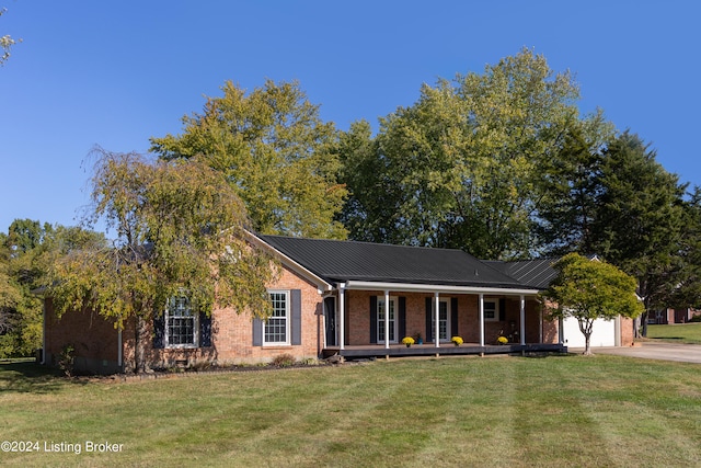 ranch-style house featuring a porch, a front lawn, and a garage