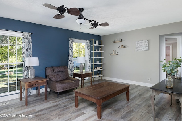 sitting room with a healthy amount of sunlight, wood-type flooring, and ceiling fan