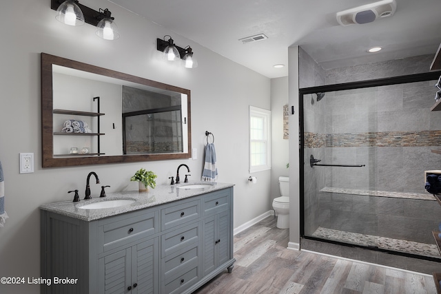 bathroom featuring vanity, toilet, hardwood / wood-style flooring, and walk in shower