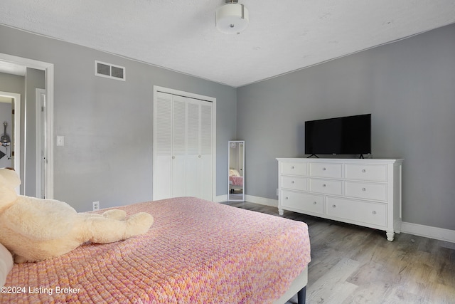 bedroom with light hardwood / wood-style flooring and a closet