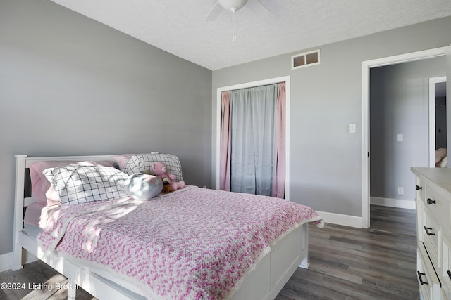 bedroom featuring a closet, a textured ceiling, dark wood-type flooring, and ceiling fan