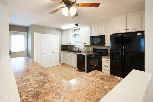 kitchen with ceiling fan, sink, black appliances, light hardwood / wood-style flooring, and white cabinetry