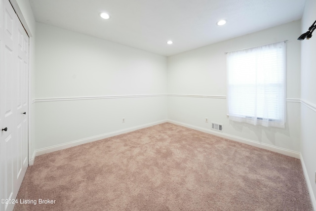 spare room featuring light colored carpet