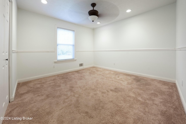 spare room featuring ceiling fan and light colored carpet