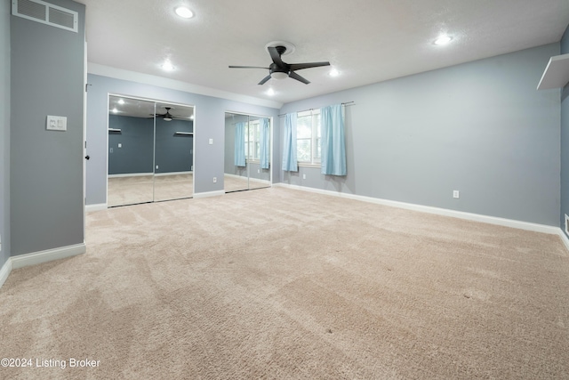 carpeted spare room featuring ceiling fan