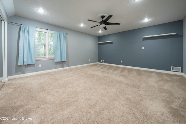 spare room featuring carpet, a textured ceiling, ceiling fan, and lofted ceiling