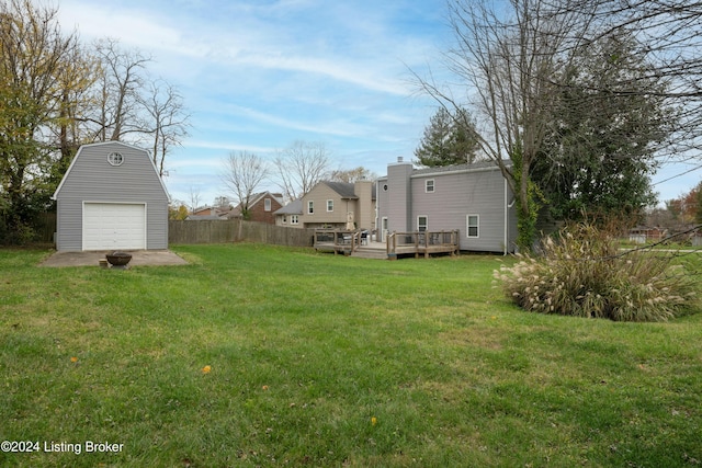 view of yard with a garage, an outdoor structure, and a wooden deck