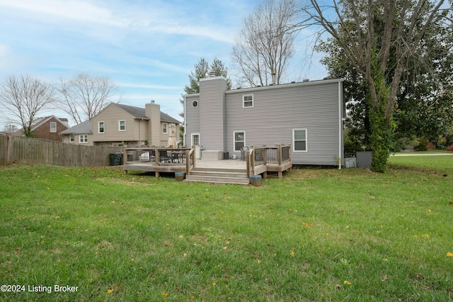 back of property with a lawn and a deck