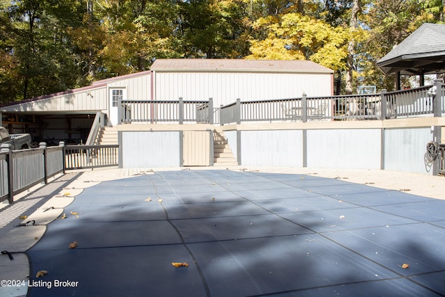 exterior space featuring a covered pool, stairs, and a wooden deck