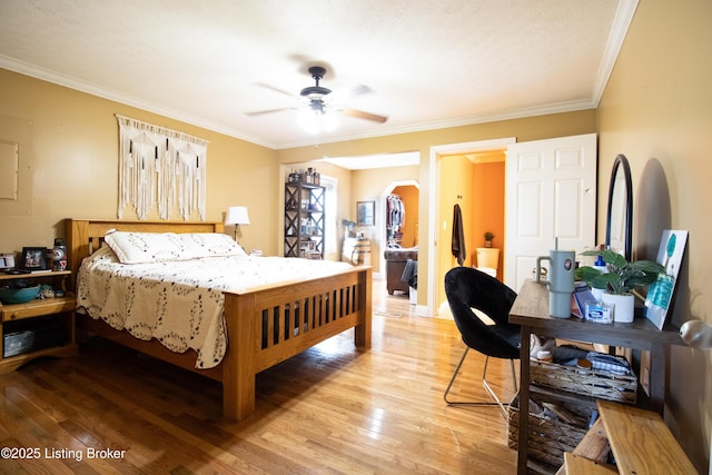 bedroom with a ceiling fan, arched walkways, wood finished floors, and ornamental molding