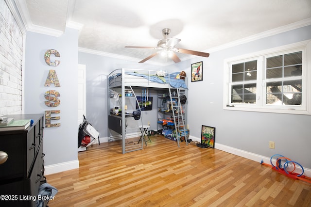 bedroom featuring baseboards, ornamental molding, ceiling fan, and wood finished floors