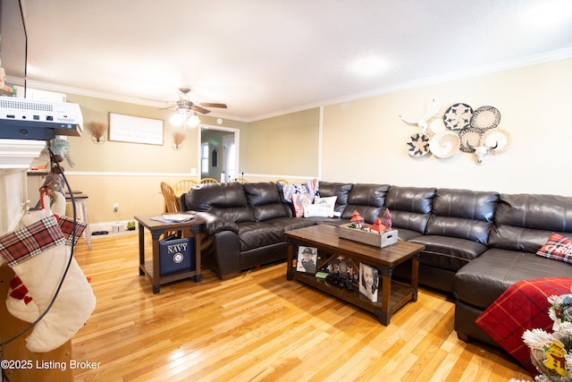 living area featuring light wood finished floors, a ceiling fan, and crown molding