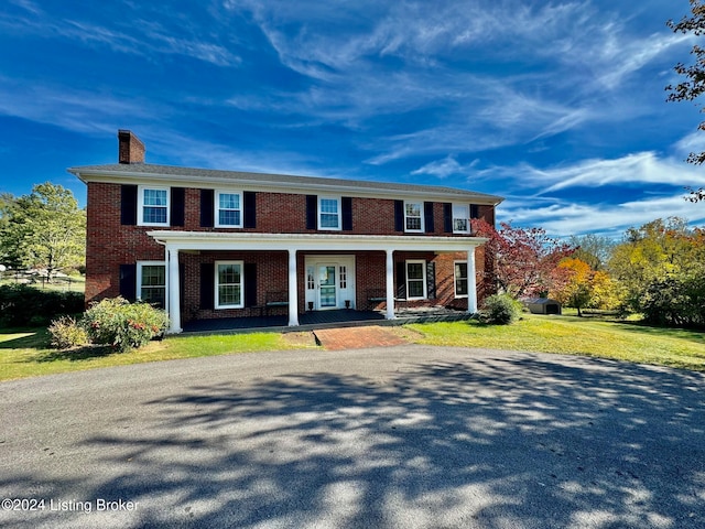 view of front of house with covered porch and a front yard