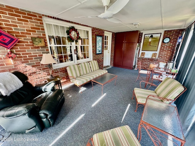 living room featuring brick wall and ceiling fan