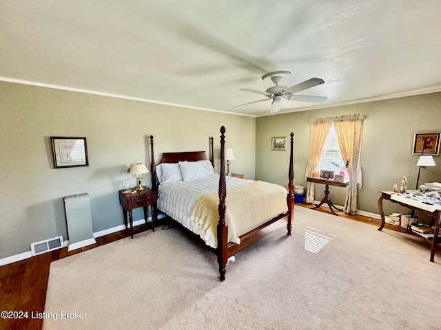 carpeted bedroom featuring crown molding and ceiling fan