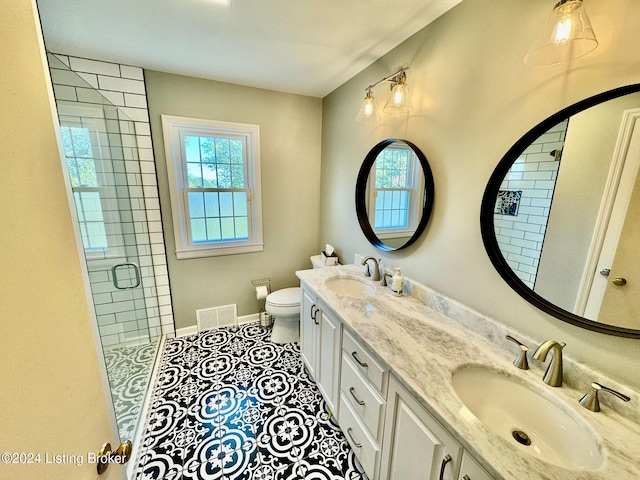 bathroom with toilet, a shower with shower door, vanity, and tile patterned floors