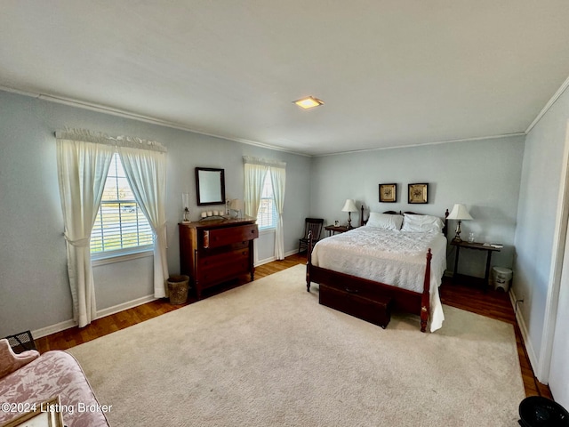 bedroom with multiple windows, hardwood / wood-style floors, and crown molding