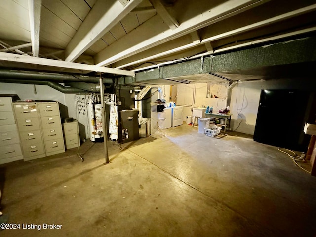 basement with water heater and washer and dryer