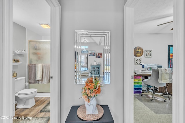 hallway with wood-type flooring and a textured ceiling