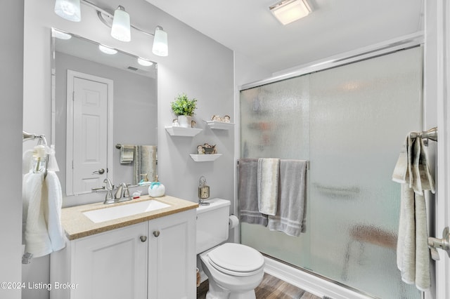 bathroom with vanity, toilet, hardwood / wood-style flooring, and walk in shower