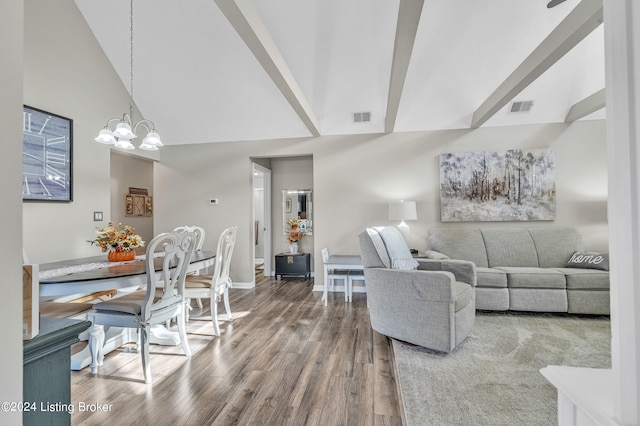 living room with a notable chandelier, hardwood / wood-style flooring, and high vaulted ceiling