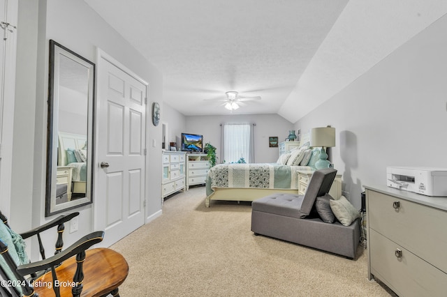 bedroom featuring ceiling fan, a textured ceiling, vaulted ceiling, and light colored carpet