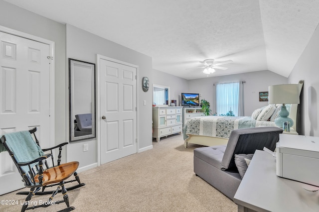 carpeted bedroom featuring ceiling fan, a textured ceiling, and lofted ceiling