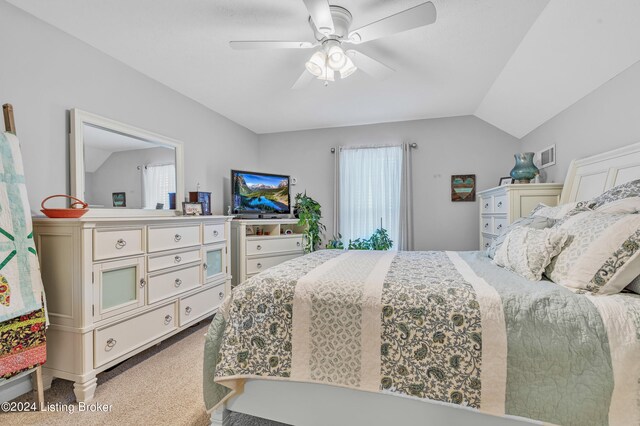 carpeted bedroom featuring lofted ceiling, multiple windows, and ceiling fan