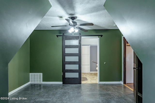 175 Boone White Rd, Leitchfield, KY 42754 - bonus room featuring a barn door, ceiling fan, a textured ceiling, baseboards, and concrete flooring