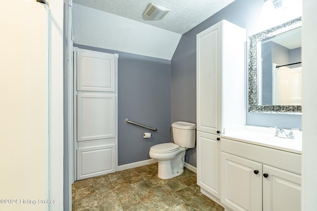 bathroom featuring toilet, lofted ceiling, a textured ceiling, and vanity