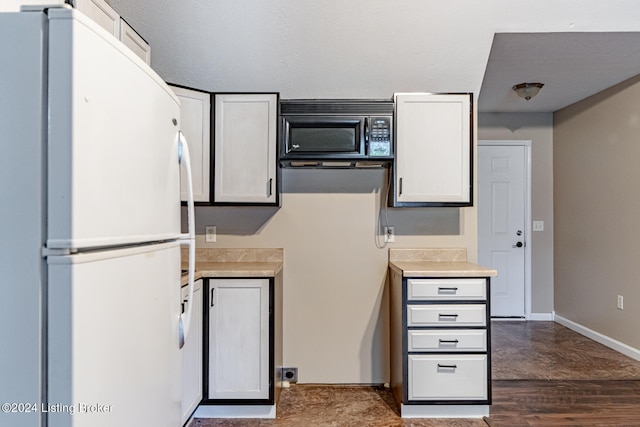 kitchen with white cabinetry, dark wood-type flooring, and white refrigerator