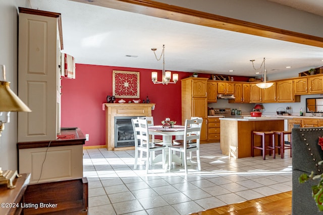 kitchen with a kitchen island, a breakfast bar, pendant lighting, light tile patterned floors, and stainless steel electric range oven