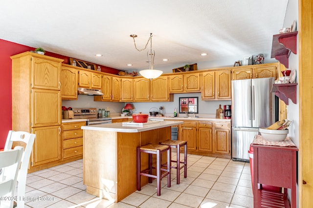 kitchen featuring a center island, stainless steel appliances, light tile patterned floors, and a breakfast bar