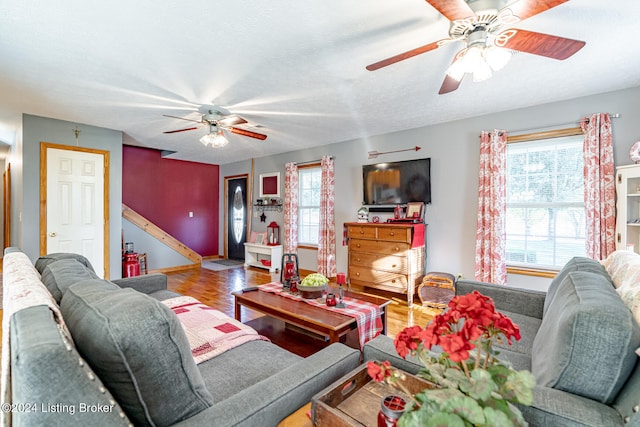 living room featuring ceiling fan, a textured ceiling, and hardwood / wood-style floors