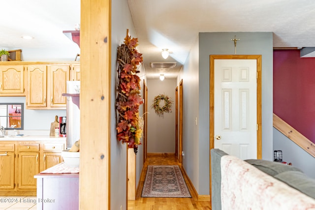 corridor with sink and light hardwood / wood-style flooring