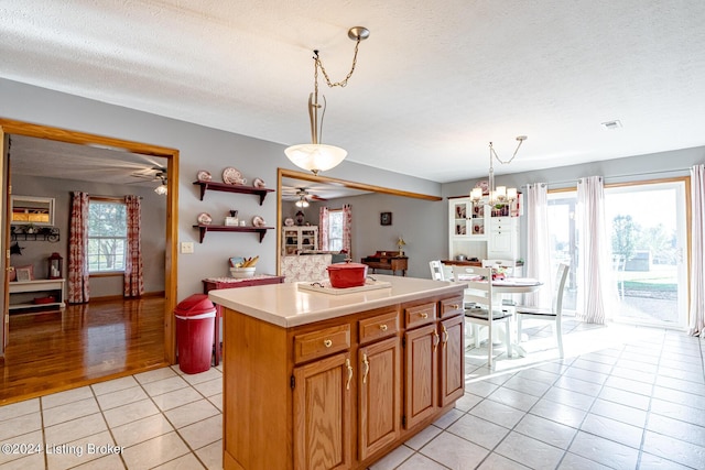 175 Boone White Rd, Leitchfield, KY 42754 - kitchen featuring a ceiling fan, light tile patterned floors, light countertops, a textured ceiling, and a center island