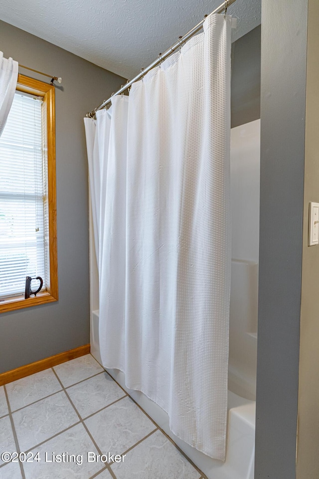 175 Boone White Rd, Leitchfield, KY 42754 - full bath featuring a textured ceiling, shower / bath combo, tile patterned flooring, and baseboards