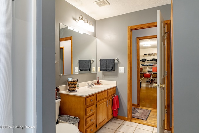 bathroom featuring vanity, toilet, hardwood / wood-style flooring, and a textured ceiling