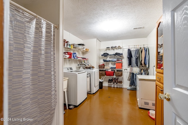 laundry room with washer and dryer and a textured ceiling